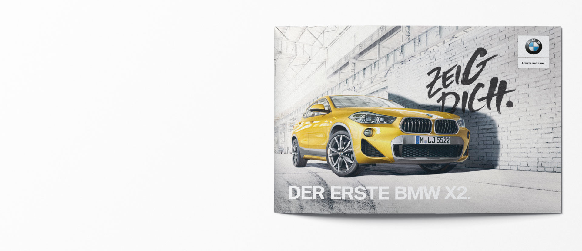 Cover der BMW X2 Broschüre: Gelber BMW X2 vor Backsteinwand, Headline „Zeig Dich." in Graffiti-Schrift, BMW Logo oben rechts.